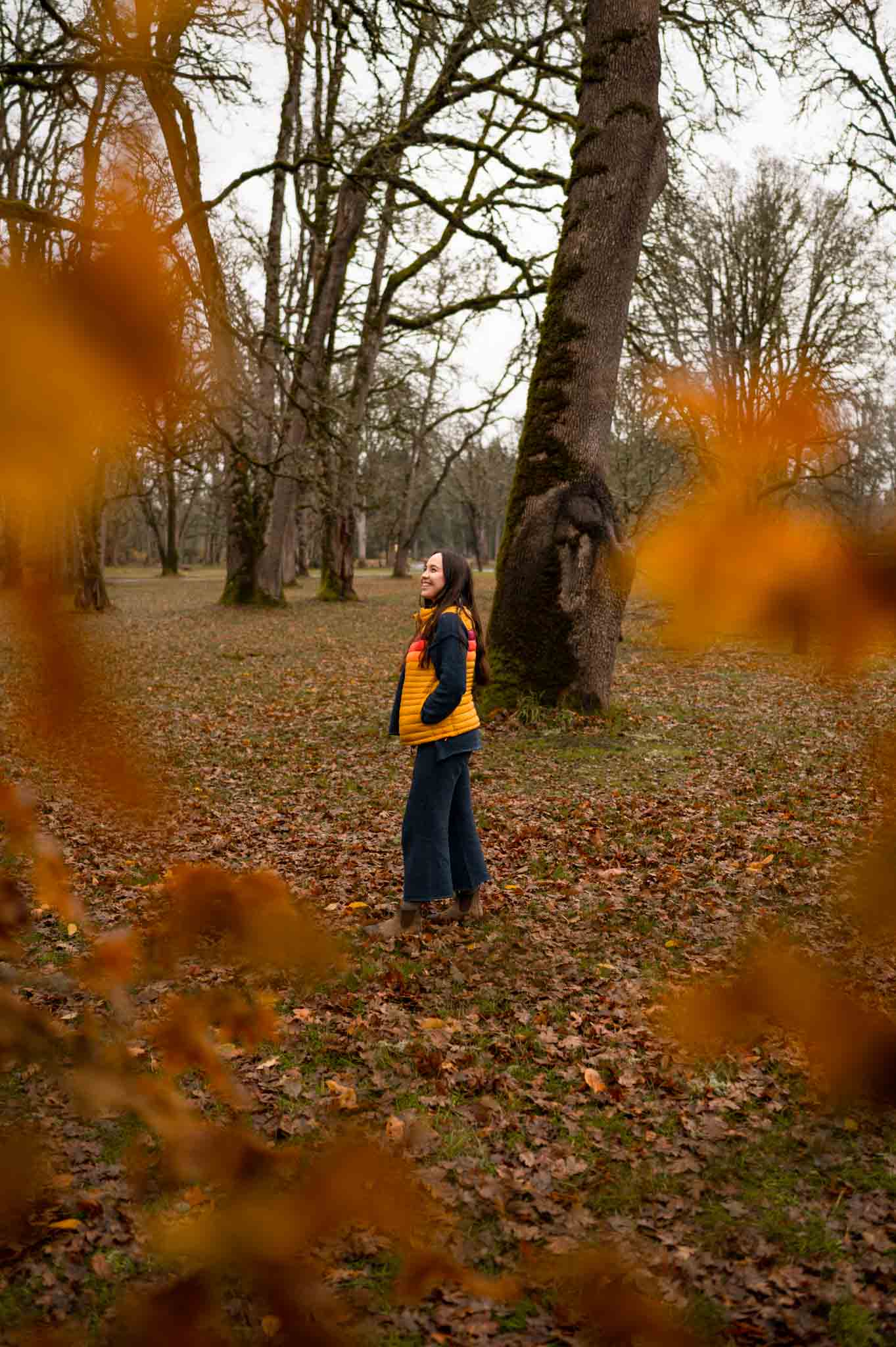 Oregon hiker wearing Free People Hailey set and Cotopaxi vest, standing in fall leaves in Wilsonville, Oregon