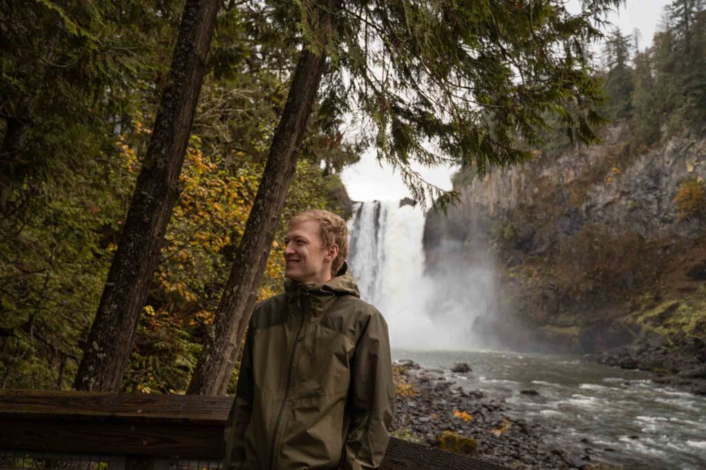 PNW hiker in front of Snoqualmie Falls in the fall